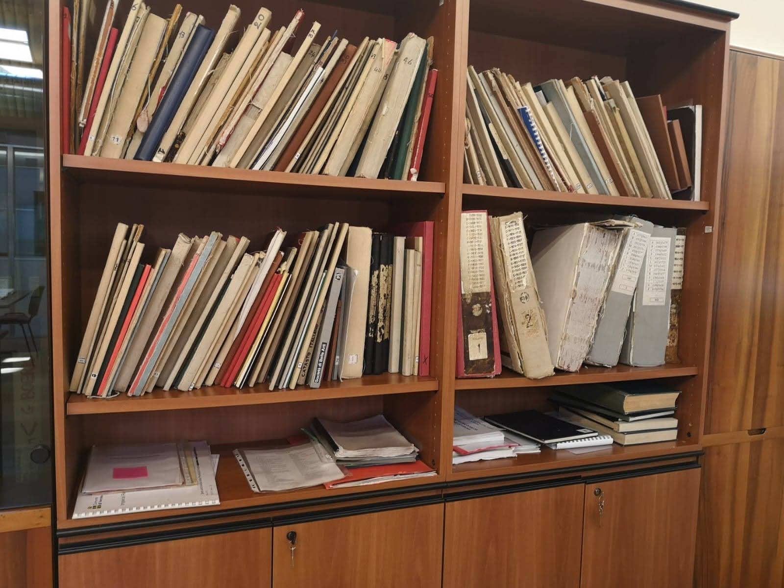 Books and folders on wooden shelves.