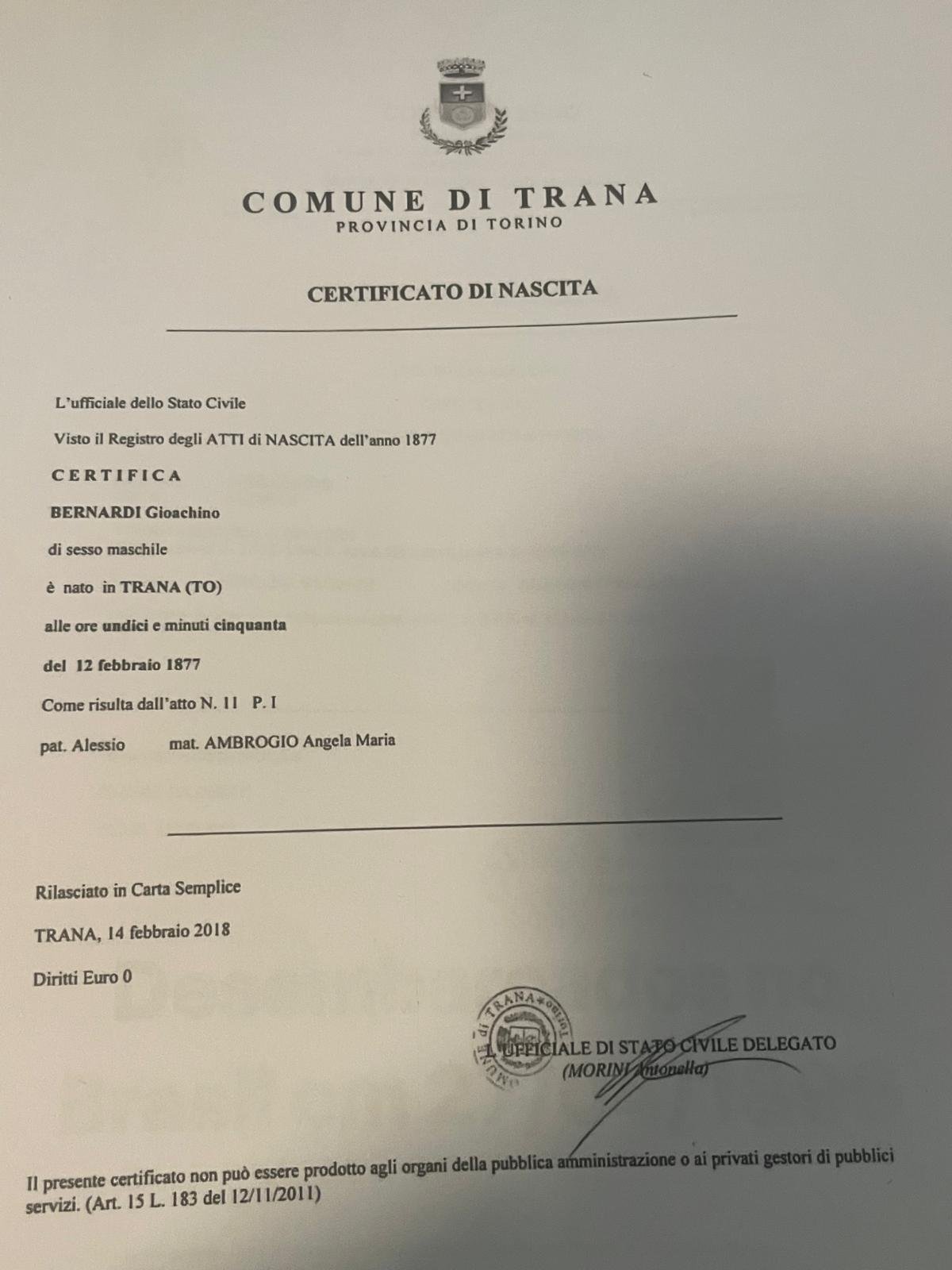 Printed birth certificate of the Comune di Trana, province of Turin: Gioachino Bernardi, born 12 February 1877 at 11:50, act 11 part I of the 1877 birth register, son of Alessio Bernardi and Angela Maria Ambrogio; issued on plain paper free of charge by the delegated civil-status officer on 14 February 2018, with the Article 15 note that it cannot be produced to public administrations.