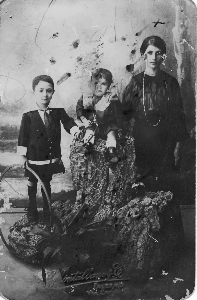 Black-and-white studio portrait of Marina Martello's grandmother with two children at the Montalbano & C. studio, Palermo, during the First World War: the photograph she sent to her husband at the front